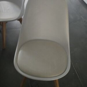 Scandinavian-style white dining chair featuring wooden legs