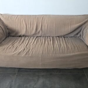 Chela - soft, Italian-style sofa featuring a loose, brown-beige fabric cover and rounded side cushions.